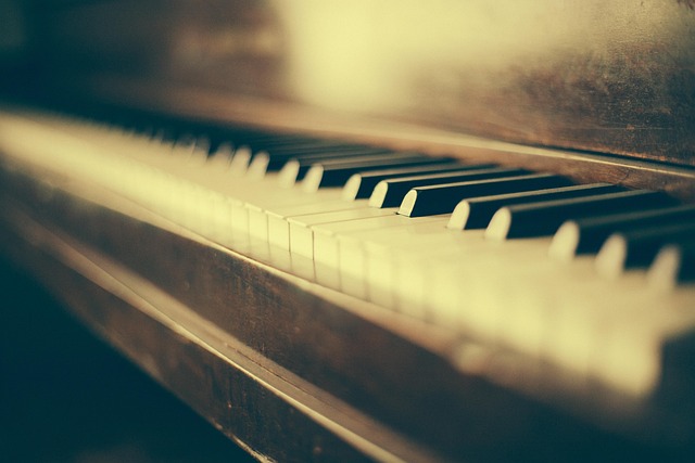 person playing grand piano with sheet music in a well-lit room